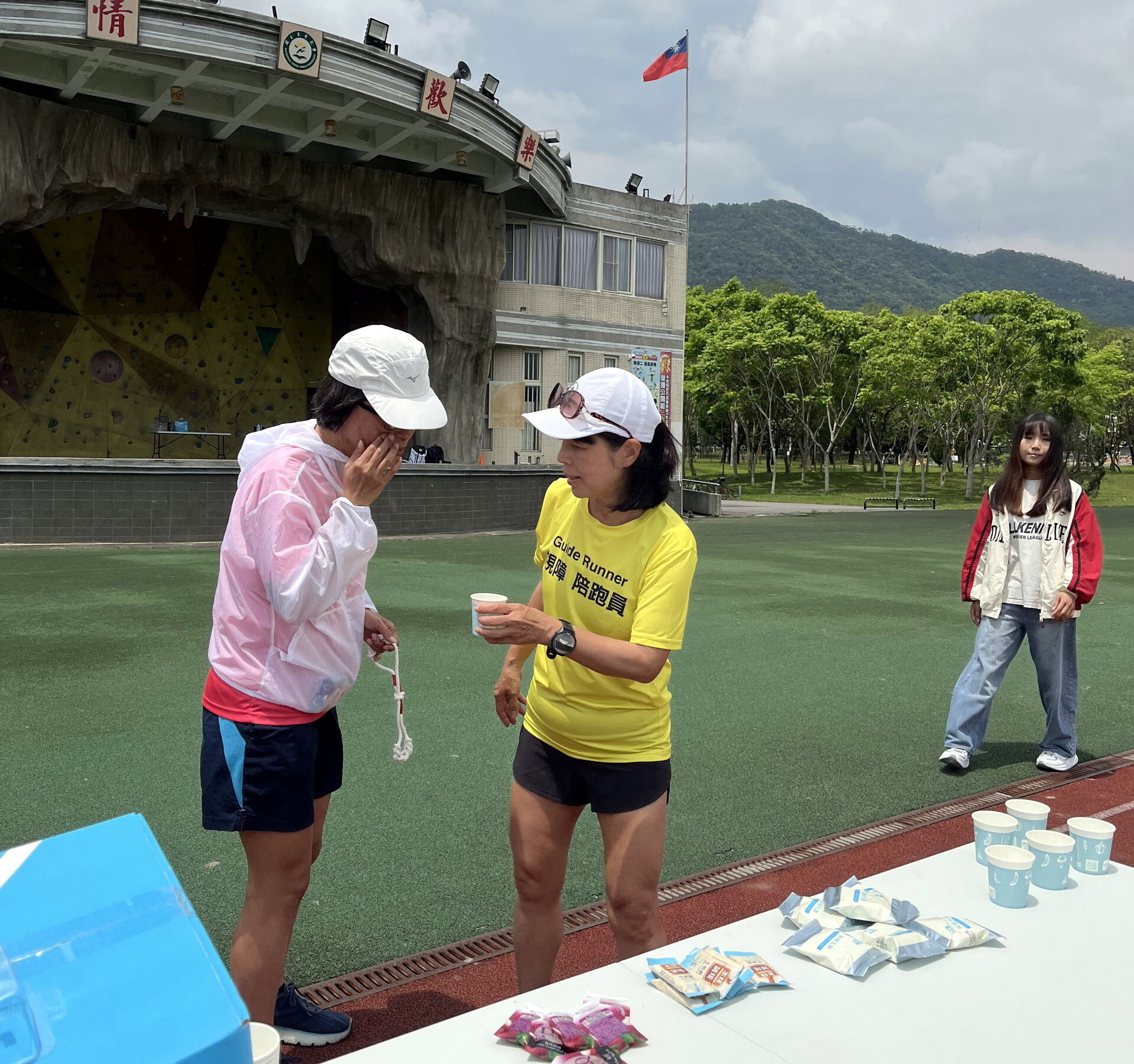 在補給站補給,視障陪跑員學習如何確保視障跑者的安全