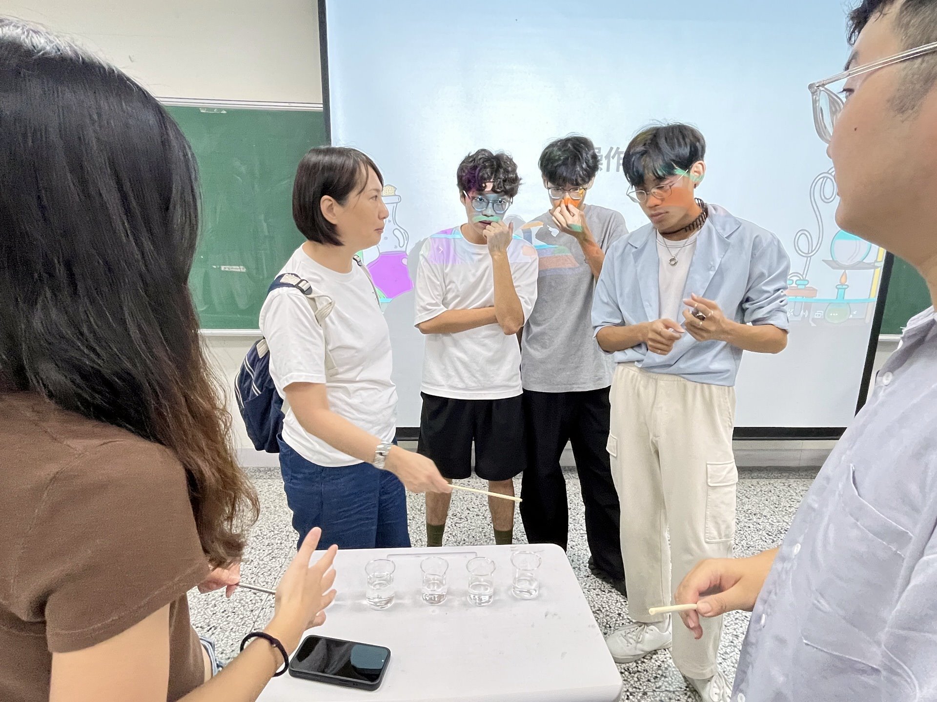 鄭立婷老師和攤位關主一同進行水杯音節科學解釋的討論